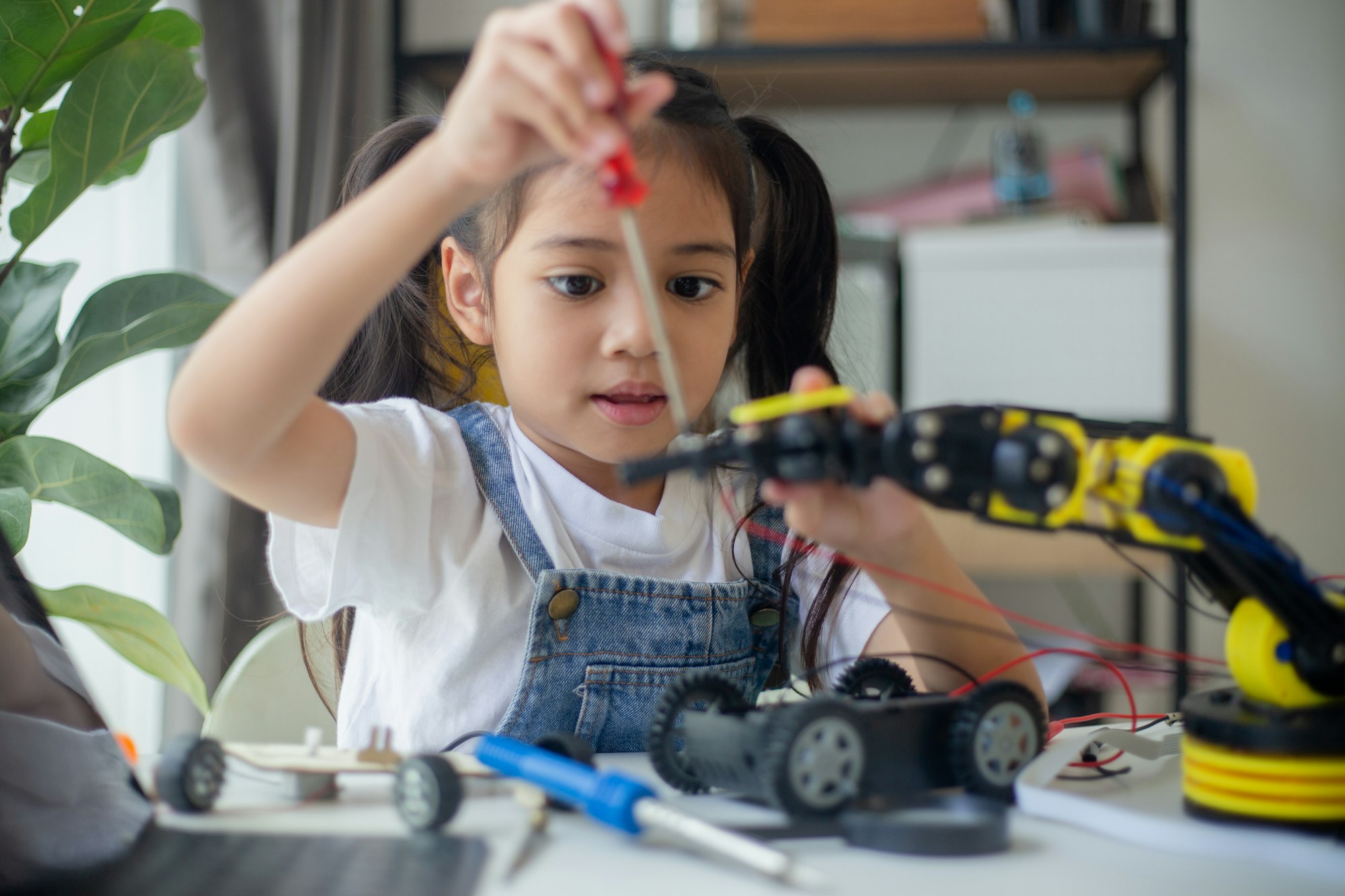 STEM education concept. Asian young girl learning robot design.